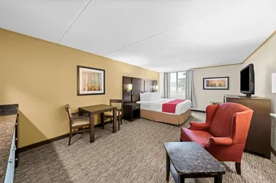 a hotel room with a bed and a table and chairs at Best Western Plus Mariposa Inn & Conference Centre in Orillia