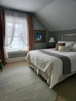 a bedroom with a large bed and a window at Stone Carriage House in Picton