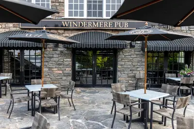 a restaurant with tables and chairs and umbrellas at Windermere House in Windermere