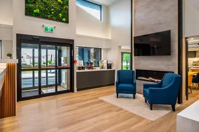 a lobby with two blue chairs and a fireplace at Comfort Inn in Guelph