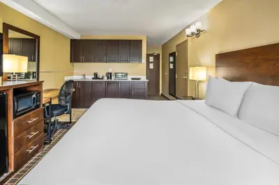 a hotel room with a large bed and a kitchen at Comfort Inn in Guelph
