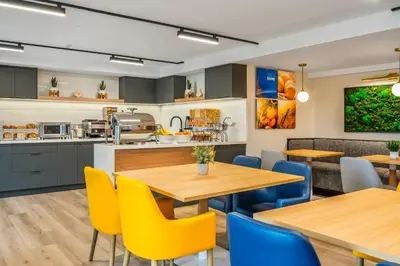a kitchen and dining room with wooden tables and yellow chairs at Comfort Inn in Guelph