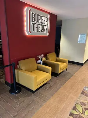 a lobby with two chairs and a burger theory sign at Holiday Inn - Mississauga Toronto West by IHG in Mississauga