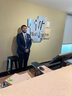 a man in a suit and tie standing in a room at Holiday Inn - Mississauga Toronto West by IHG in Mississauga