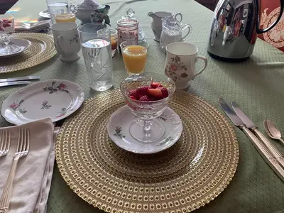 a table with a bowl of fruit on a plate at Green Oaks B&B in Niagara on the Lake