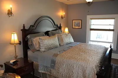 a bedroom with a bed and two lamps and a window at Green Oaks B&B in Niagara on the Lake