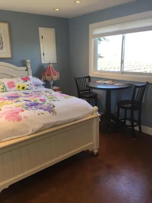 a bedroom with a bed and a table and a window at Green Oaks B&B in Niagara on the Lake