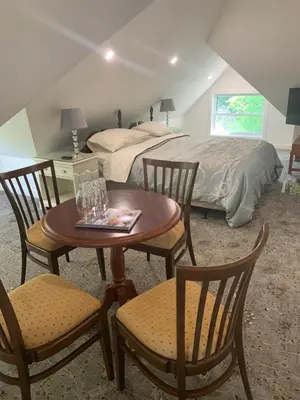a bedroom with a bed and a table and chairs at Green Oaks B&B in Niagara on the Lake