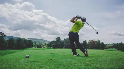 a man swinging a golf club on a field at Holiday Inn & Suites Oakville at Bronte by IHG in Oakville