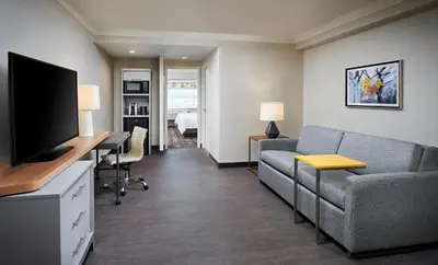 a living room with a couch and a desk with a television at Holiday Inn & Suites Oakville at Bronte by IHG in Oakville