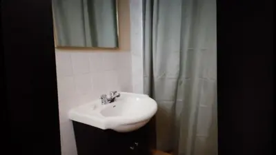 a bathroom with a sink and a shower curtain at Star Inn by Elevate Rooms in Niagara Falls