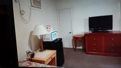 a bedroom with a television and a dresser with a lamp at Star Inn by Elevate Rooms in Niagara Falls