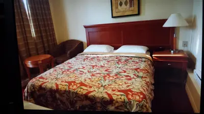 a bedroom with a bed and a table and a lamp at Star Inn by Elevate Rooms in Niagara Falls