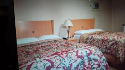a hotel room with two beds and a lamp at Star Inn by Elevate Rooms in Niagara Falls