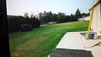 a yard with a field of green grass next to a house at Star Inn by Elevate Rooms in Niagara Falls