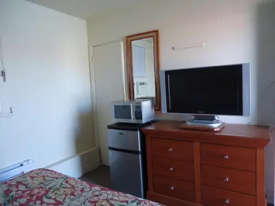 a bedroom with a tv on a dresser with a bed at Star Inn by Elevate Rooms in Niagara Falls