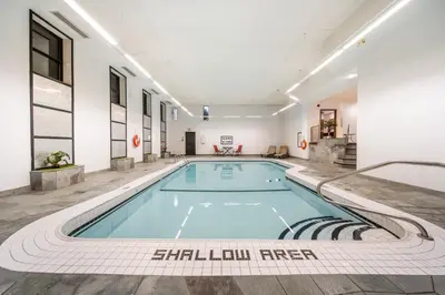 a large swimming pool in a building with at Ramada Plaza by Wyndham Niagara Falls in Niagara Falls