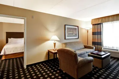 a hotel room with a bed and a chair at Homewood Suites by Hilton Toronto Airport Corporate Centre in Toronto