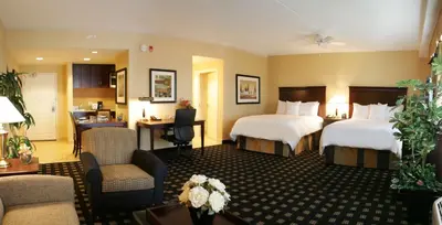 a hotel room with two beds and a desk at Homewood Suites by Hilton Toronto Airport Corporate Centre in Toronto