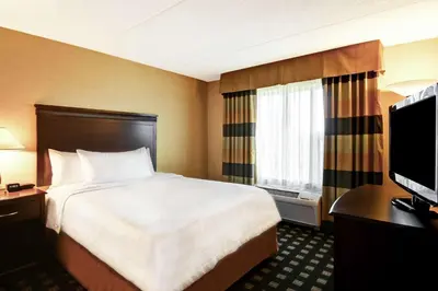 a hotel room with a bed and a desk and a television at Homewood Suites by Hilton Toronto Airport Corporate Centre in Toronto