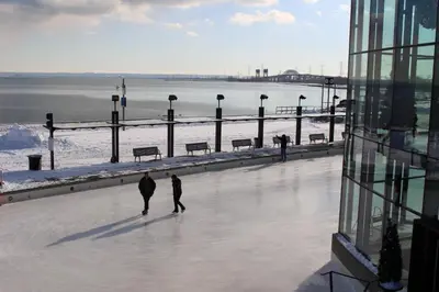 two people walking on an ice rink next to a building at Holiday Inn Burlington Conference Centre by IHG in Burlington