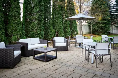 a patio with chairs and tables and an umbrella at Holiday Inn Express & Suites Kitchener Southeast by IHG in Kitchener
