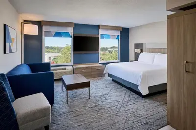 a hotel room with a bed and a couch and a chair at Holiday Inn Express & Suites Kitchener Southeast by IHG in Kitchener