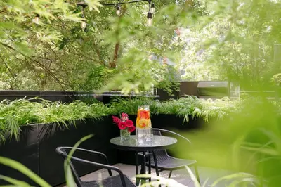 a small table with a vase of flowers on it at The Anndore House, part of JDV by Hyatt in Toronto