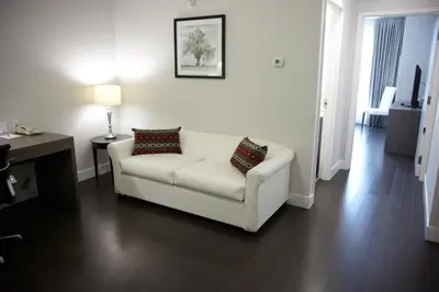 a living room with a white couch and a table at Admiral Inn Mississauga in Mississauga