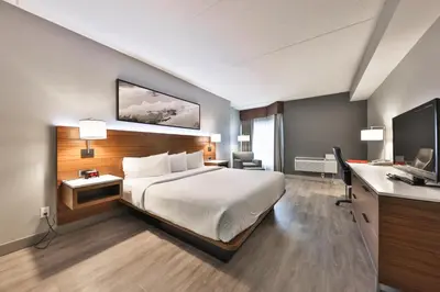 a hotel room with a bed and a desk at Admiral Inn Mississauga in Mississauga