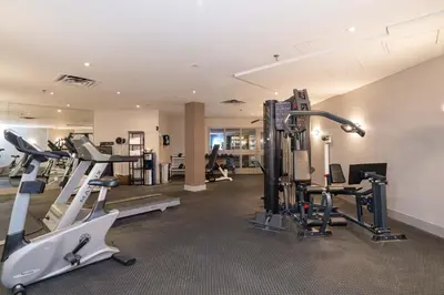 a gym with treadmills and machines in a room at Sandman Signature Mississauga Hotel in Mississauga