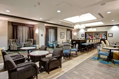 a restaurant with tables and chairs and a bar at Hampton Inn by Hilton Toronto Airport Corporate Centre in Toronto