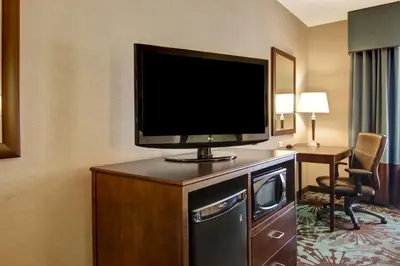 a flat screen tv on top of a dresser in a hotel room at Hampton Inn by Hilton Toronto Airport Corporate Centre in Toronto