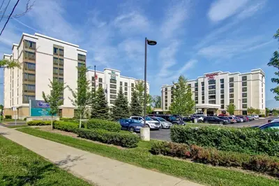 a row of white buildings in a parking lot at Hampton Inn by Hilton Toronto Airport Corporate Centre in Toronto