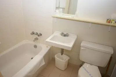 a bathroom with a sink and a tub and a toilet at The Alexandra Hotel in Toronto