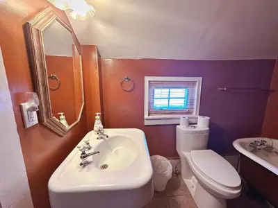 a bathroom with a sink and a toilet and a mirror at WHITE SWAN House in Niagara Falls