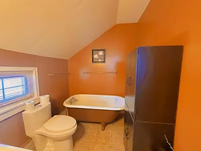 a bathroom with a tub and a toilet and a sink at WHITE SWAN House in Niagara Falls
