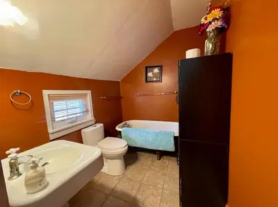 a bathroom with a sink and a toilet and a tub at WHITE SWAN House in Niagara Falls