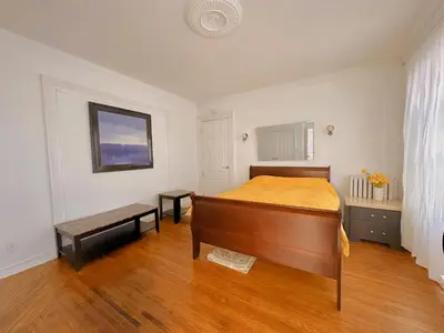a bedroom with a bed and a wooden floor at WHITE SWAN House in Niagara Falls