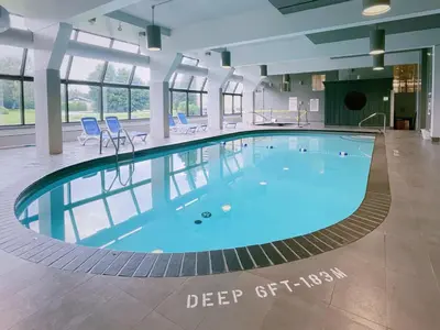 a large pool with blue water in a building at Briars Resort and Spa in Georgina
