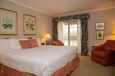 a bedroom with a large bed and a chair and a window at Briars Resort and Spa in Georgina