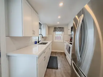 a kitchen with white cabinets and a refrigerator at Addison House License# 004-2025 in Niagara on the Lake