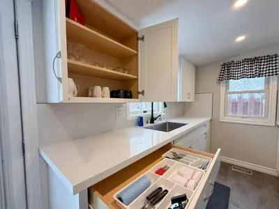 a kitchen with white cabinets with an open drawer at Addison House License# 004-2025 in Niagara on the Lake