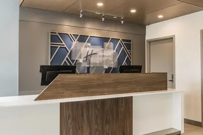 an office lobby with a reception counter with a painting at Holiday Inn Express Toronto-North York by IHG in Toronto