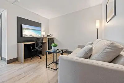 a living room with a couch and a desk at The Jordan Hotel Ramada by Wyndham in Jordan