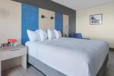 a hotel room with a large bed and a desk at The Jordan Hotel Ramada by Wyndham in Jordan