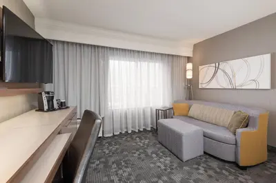 a hotel room with a couch and a table at Courtyard by Marriott Toronto Vaughan in Vaughan