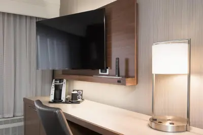 a room with a desk with a television and a lamp at Courtyard by Marriott Toronto Vaughan in Vaughan