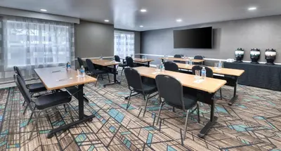 a conference room with tables and chairs and a flat screen tv at Residence Inn by Marriott Whitby in Whitby