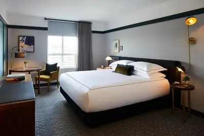 a hotel room with a large bed and a desk at Kimpton Saint George Hotel by IHG in Toronto